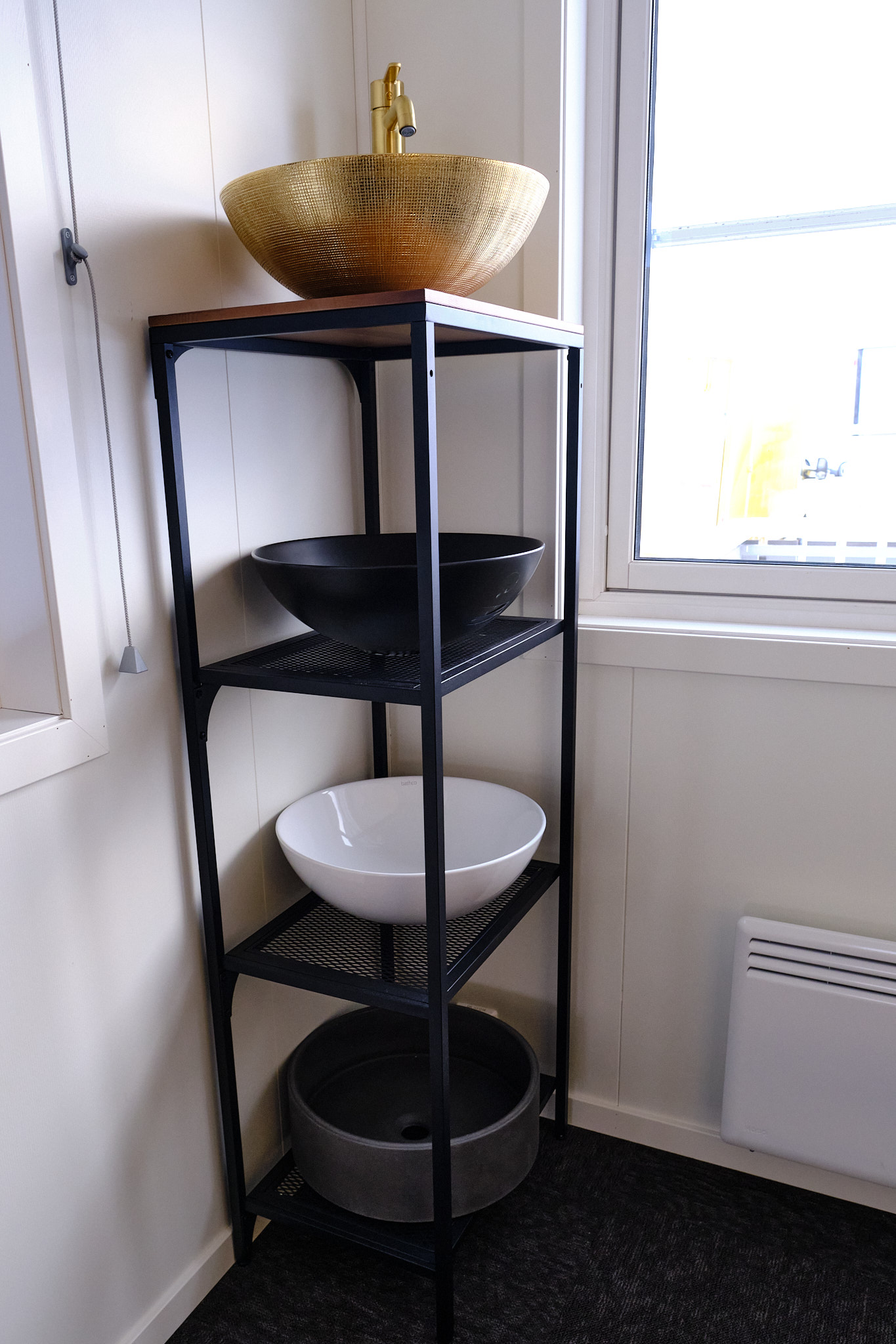 To bolleservanter, en hvit og en sort, utstilt i en hylle i utstillingslokalet til Rørservice Innlandet i Furnes.