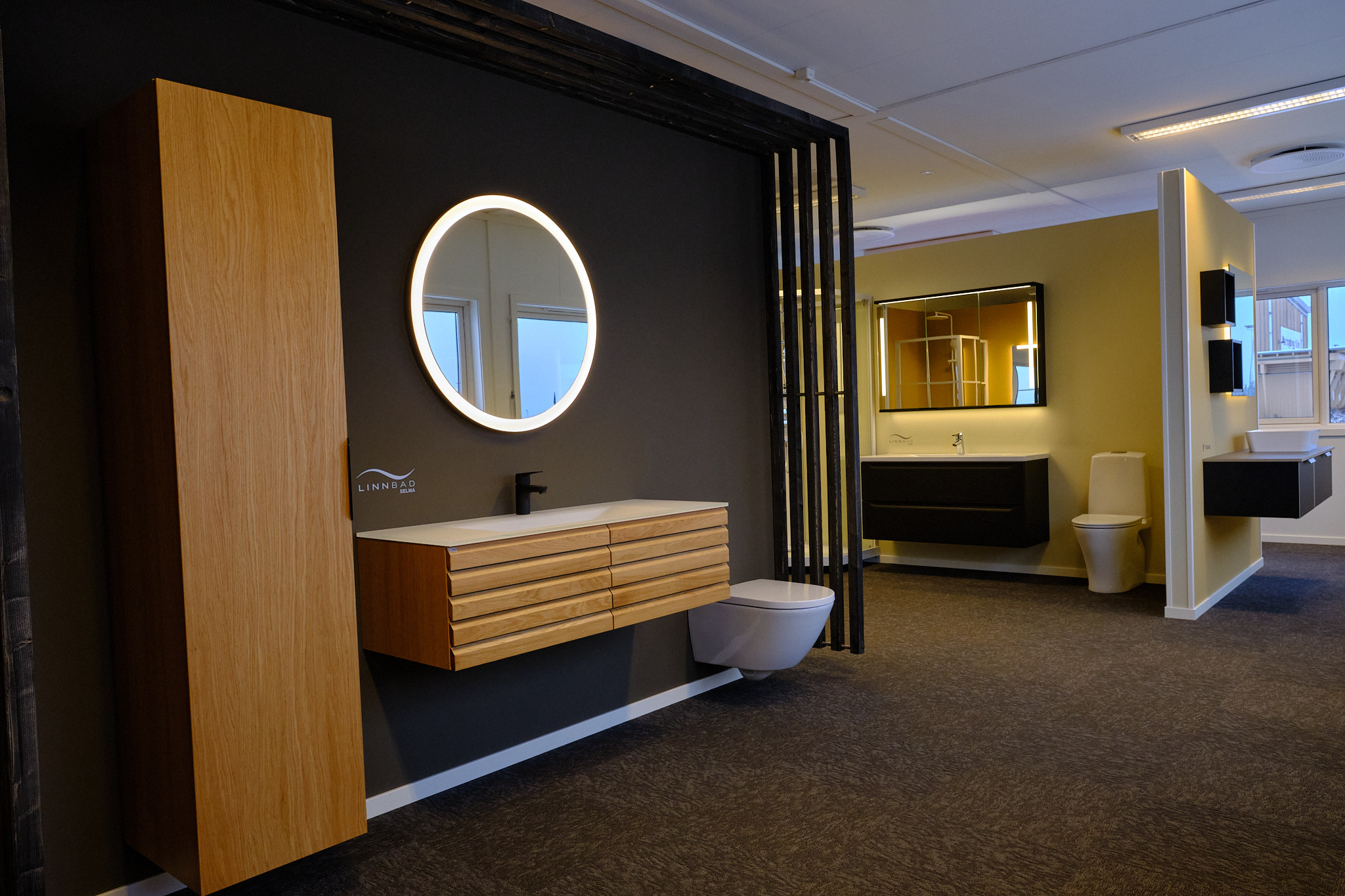 Baderomsmøbel i eik med høyskap og rundt speil fra Linn Bad.